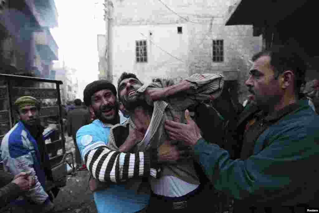 A father reacts after the death of two of his children whom activists said were killed by shelling by forces loyal to Syria&#39;s President Bashar al-Assad, in al-Ansari, Aleppo, Syria, January 3, 2013. 