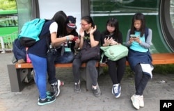 South Korean middle school students wait at a bus station in Seoul, South Korea, May 15, 2015.