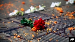 FILE - Flowers lie at the site where Avijit Roy was attacked and killed, in Dhaka, Bangladesh on Feb. 27, 2015. Roy, a prominent Bangladeshi-American blogger, known for speaking out against religious fundamentalism was hacked to death in the streets of Bangladesh's capital as he walked with his wife, police said Friday.