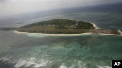 Photographed through the window of a closed aircraft, an aerial view shows Pagasa Island, part of the disputed Spratly group of islands, in the South China Sea located off the coast of western Philippines Wednesday July 20, 2011. 