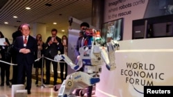 Technologies like robotics are seen as a driver of the so-called Fourth Industrial Revolution. HUBO, a walking humanoid robot performs a demonstration of its capacities next to its developer Oh Jun-Ho during the annual meeting of the World Economic Forum.