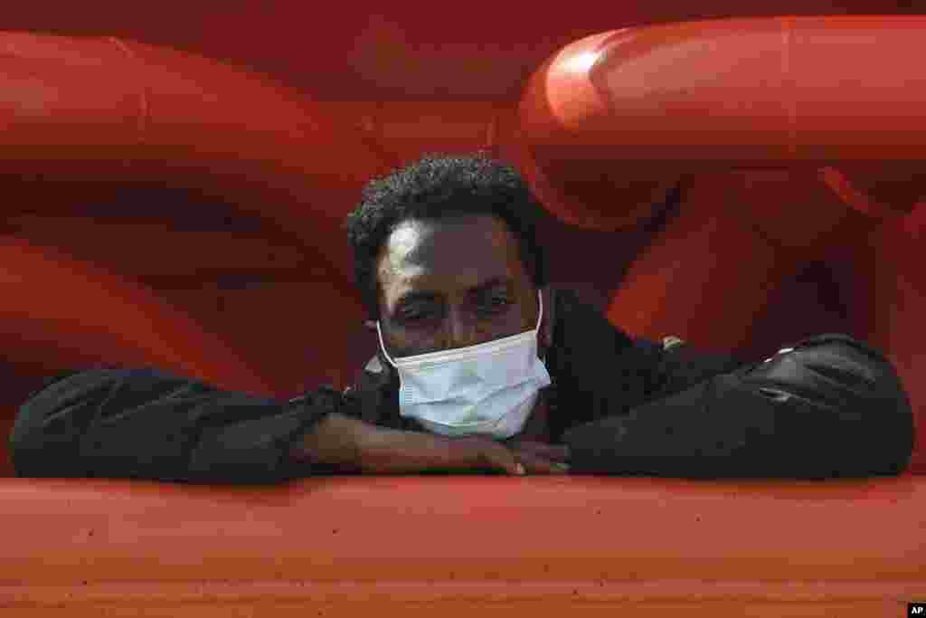 A man aboard the Asso Trenta ship waits to be transferred on the quarantine ship Gnv Azzurra, on the Sicilian island of Lampedusa, southern Italy.