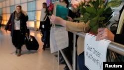 Opponents of U.S. President Donald Trump's executive order travel ban greet international travelers at Logan Airport in Boston, Massachusetts, Feb. 3, 2017.