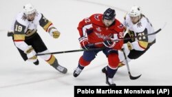 Napadač Vašington Kapitalsa Evgenij Kuznjecov (92) u duelu sa dvojicom hokejaša Vegasa - Rajlijem Smitom (levo) i Vilijamom Karlsonom (desno) u drugoj trećini treće utakmice finala Stenli kupa (Foto: AP/Pablo Martinez Monsivais)