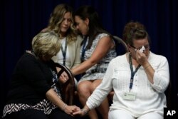 FILE - Victims of clergy sexual abuse, or their family members react as Pennsylvania Attorney General Josh Shapiro speaks during a news conference at the Pennsylvania Capitol in Harrisburg, Aug. 14, 2018.