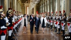 French president Francois Hollande, center, flanked by his companion Valerie Trierweiler, right, Paris' mayor Bertrand Delanoe, second left,and Paris' deputy mayor Anne Hidalgo arrives to deliver a speech as part of a ceremony held at Paris' town hall, Pa