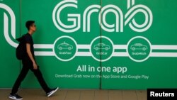 Seorang pria berjalan melewati kantor Grab di Singapura, 26 Maret 2018.