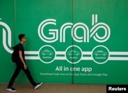 A man walks past a Grab office in Singapore, March 26, 2018.