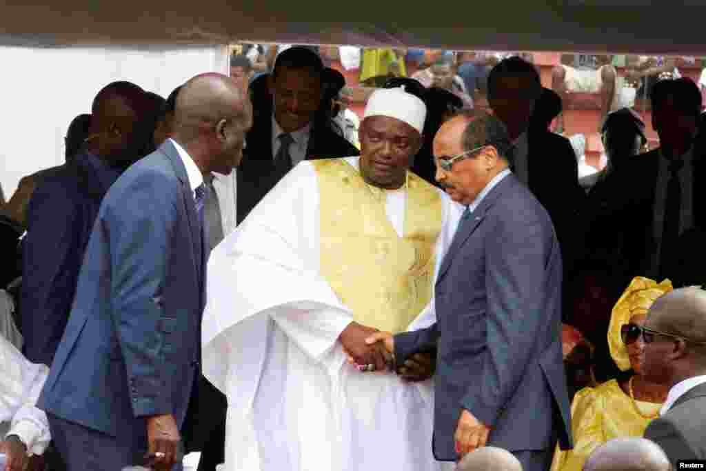 Le Président de la Gambie, Adama Barrow, au centre, salue son homologue de la Mauritanie, Mohamed Ould Abdel Aziz, à droite, lors de sa prestation de serment et de la célébration de la journée de l'indépendance de la Gambie au Stade de l'Indépendance, à B