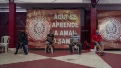 In front of banners reading “Here you learn to love samba,” residents suspected of suffering COVID-19 wait to be attended by Dr. Wille Baracho inside the Unidos de Padre Miguel samba school in the Vila Vintem slum of Rio de Janeiro, Brazil, May 24, 2020.