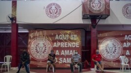 In front of banners reading “Here you learn to love samba,” residents suspected of suffering COVID-19 wait to be attended by Dr. Wille Baracho inside the Unidos de Padre Miguel samba school in the Vila Vintem slum of Rio de Janeiro, Brazil, May 24, 2020.