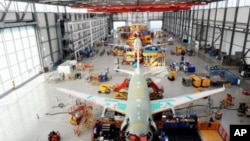 Airbus employess work on an A320 at the Airbus plant in Hamburg-Finkenwerder, northern Germany, February 23, 2011