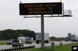 A sign warns of a Texas coastal hurricane watch as traffic passes by in Hutchins, Texas, Aug. 24, 2017.