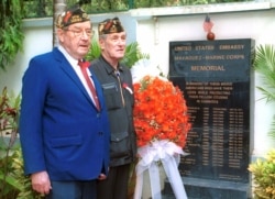 FILE PHOTO - Joseph Carsley, left, and Leon "Nick" Vileo, right, of Toledo, Ohio, both officials of the United States Veterans of Foreign Wars, stand in front of the memorial to fallen American Marines at the residence of the American Ambassador to Cambodia, in Phnom Penh Monday, May 15, 2000. Monday marked the 25th anniversary of the ill-fated mission by U.S. Marines to rescue the crew of the merchant's vessel Mayaguez, on Koh Tang island off Cambodia's southern coast. Eighteen U.S. servicemen died in the engagement. (AP Photo/Andy Eames)