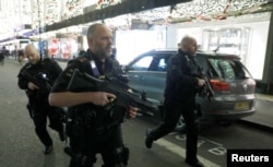 Armed police run along Oxford Street, London, Britain, Nov. 24, 2017.