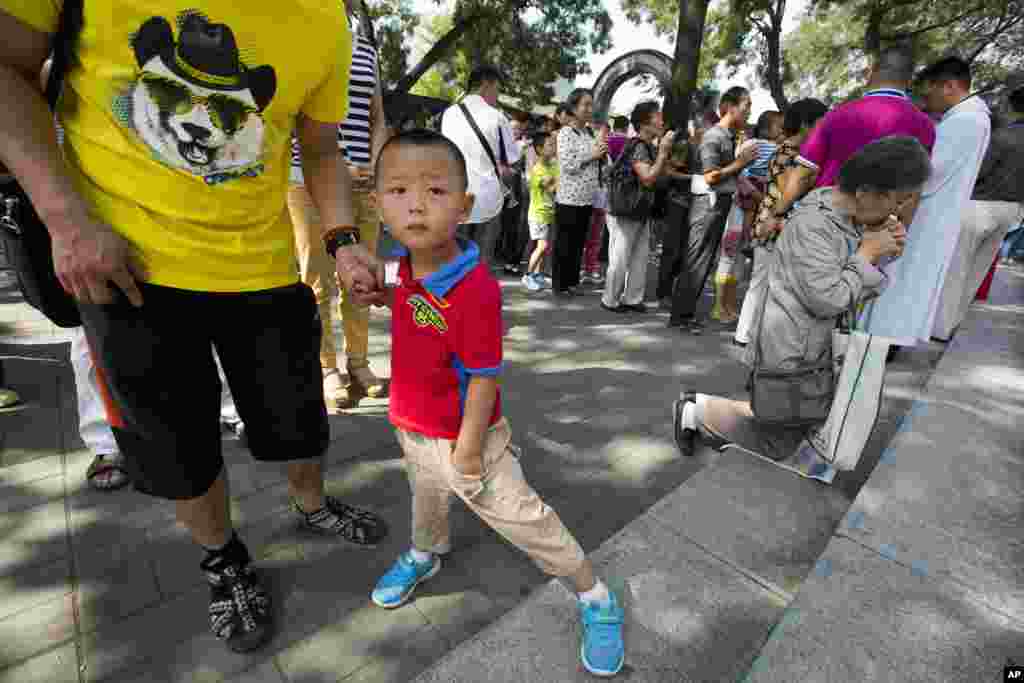 Para penganut Katolik ikut ambil bagian dalam misa di luar Katedral Immaculate Conception yang berusia 400 tahun di Beijing. Umat Katolik China pada hari Jumat menyambut kunjungan Paus Francis ke negara tetangga Korea Selatan itu, mengatakan mereka berharap perjalanan ke wilayah mereka itu akan membantu mengakhiri keterasingan hubungan antara Beijing dan Vatikan. &nbsp;