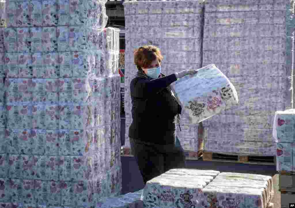 A woman gathers toilet paper at a a &#39;toilet paper drive in&#39; in a parking area in Dornburg, some 60 kilometers west of Frankfurt, Germany.