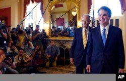   El candidato a la Corte Suprema Brett Kavanaugh, a la derecha, y el senador Chuck Grassley, republicano de Iowa, segundo desde la derecha, caminan frente a la prensa después de posar para los fotógrafos en Capitol Hill en Washington 10 de julio. 2018. 