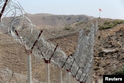 FILE - A view of the fence outside the Kitton outpost on the border with Afghanistan in North Waziristan, Pakistan, Oct. 18, 2017.