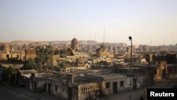 A person stands near part of the Cairo Necropolis, Egypt, Oct. 14, 2015. In the sprawling Cairo Necropolis, known as the City of the Dead, life and death are side by side. 