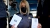 Офіцерка європейської поліції демонструє ковідний паспорт ЄС 