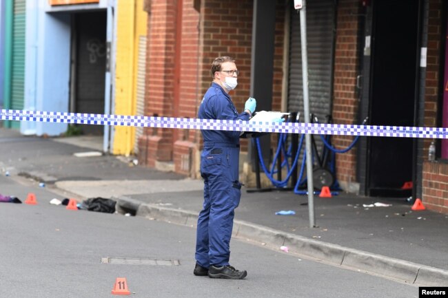 A Victoria Police employee works at the scene of a multiple shooting outside Love Machine nightclub in Prahran, Melbourne, Australia, April 14, 2019.