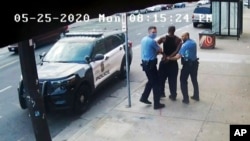 FILE - Minneapolis police Officers Thomas Lane, left, and J. Alexander Kueng, right, escort George Floyd, center, to a police vehicle outside Cup Foods in Minneapolis, on May 25, 2020, in this image from video.