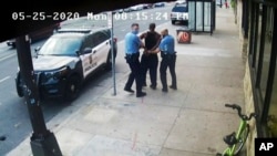 FILE - Minneapolis police Officers Thomas Lane, left, and J. Alexander Kueng, right, escort George Floyd, center, to a police vehicle outside Cup Foods in Minneapolis, on May 25, 2020, in this image from video.