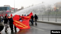 FILE - Protesters run from water cannons used by riot police to disperse a rally in Istanbul March 11, 2015.