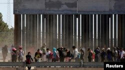 FILE - Migrants queue to request asylum after crossing illegally into El Paso, in this picture taken from Ciudad Juarez, Mexico, April 21, 2019.