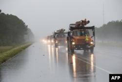 Tree-trimming trucks head into Biloxi, Miss., which was under a hurricane warning as Hurricane Nate approached the Mississippi Gulf Coast, Oct. 7, 2017.