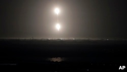 The SpaceX Falcon heavy rocket boosters return to land after a successful launch from the Kennedy Space Center in Cape Canaveral, Fla., early Tuesday, June 25, 2019. (AP Photo/John Raoux)