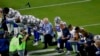 Dalas Kaubojs, predvođeni vlasnikom Džerijem Džonson, kleče pred početak NFL utakmice protiv Arizona Kardinalsa.