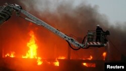 Seorang petugas pemadam kebakaran berusaha memadamkan api di sebuah pabrik garmen di Karachi, 2 Mei 2009. (Foto: Reuters)