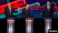 Presidential candidate Donald Trump (L) responds to criticism from former Governor Jeb Bush (R) as Senator Ted Cruz (C) looks on during the Republican presidential debate in Las Vegas.
