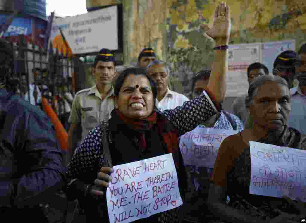 An Indian woman shouts at a police officer during a gathering of people to mourn the death of the 23-year-old gang rape victim in Mumbai, Saturday, Dec. 29, 2012.