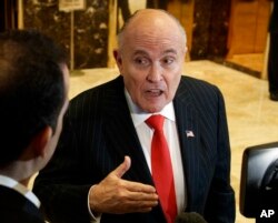 FILE - Former New York City Mayor Rudy Giuliani talks with reporters in the lobby of Trump Tower in New York, Jan. 12, 2017.