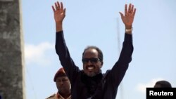 Somalia's President Hassan Sheikh Mohamud waves to the guests as he arrives for Independence Day celebrations outside the ruins of the former parliament buildings in Somalia's capital, Mogadishu, July 1, 2016.