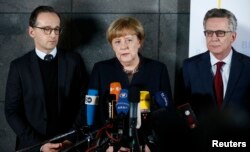 Nemačka kancelarka Angela Merkel, ministar pravde Heiko Mas (levo) i ministar unitrašnjih poslova Tomas de Mezier tokom davanja izjave nakon posete Saveznom uredu policije za borbu protiv kriminala u Berlinu