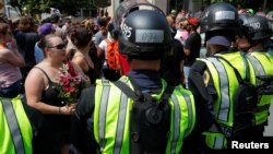 Police in riot gear block demonstrators at the site where Heather Heyer was killed, on the one year anniversary of 2017 Charlottesville "Unite the Right" protests, in Charlottesville, Virginia, Aug. 12, 2018.