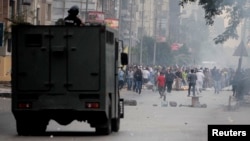 FIILE - Egyptian security forces clash with supporters of ousted president Mohamed Morsi at Nasr City district in Cairo, Nov. 22, 2013. 