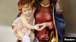 FILE - A statue of Saint Mary and an infant Jesus are displayed for sale in a religious souvenir shop in Rome.