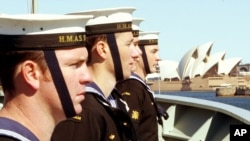 FILE - Sailors onboard Australia's HMAS Stuart line the upper decks as the ship sails towards the Sydney Opera House on returning from duty in the Middle East, Sept. 10, 2004. 