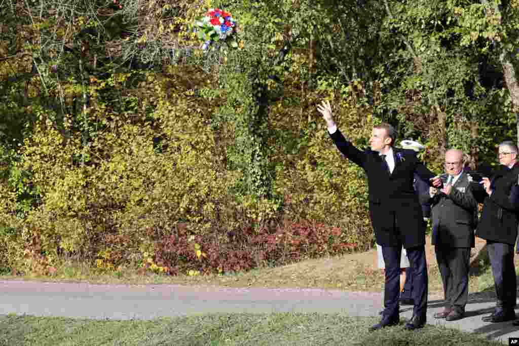 French President Emmanuel Macron throws flowers at Les Entonnoirs, in Les Eparges, France, as part of the ceremonies to mark 100 years since the the end of World War I.