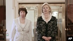US Secretary of State Hillary Clinton, right, and EU Foreign Policy chief Catherine Ashton, walk in together before the signing of US-EU framework at the State Dept. Building in Washington, May 17, 2011