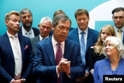 Leader of the Brexit Party Nigel Farage, center, speaks as he and newly elected Members of the European Parliament from Brexit Party attend a news conference following the results of the European Parliament elections, in London, May 27, 2019.