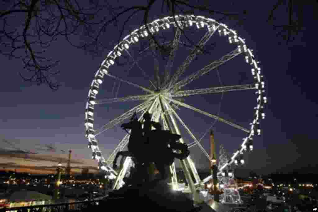 Night view of the ferris wheel set up for the Christmas period on the Place de la Concorde, in Paris, Wednesday Dec. 7, 2011. Visible at left is the Eiffel Tower.(AP Photo/Remy de la Mauviniere)