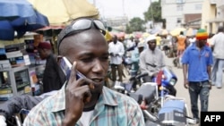 A motorcyclist talks on his cell phone in Obalende, a district of Lagos, August 18, 2008.