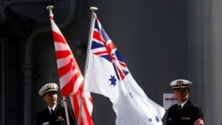 Crew members from the Japanese Maritime Self-Defense force ship Umigiri stand on deck between Japan's Self-Defense Force flag alongside an Australian flag before joint exercises at Garden Island Naval Base in Sydney, April 19, 2016.