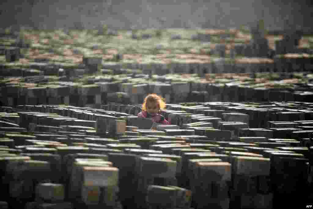 A girl stands at a brick factory near the central Iraqi shrine city of Najaf.